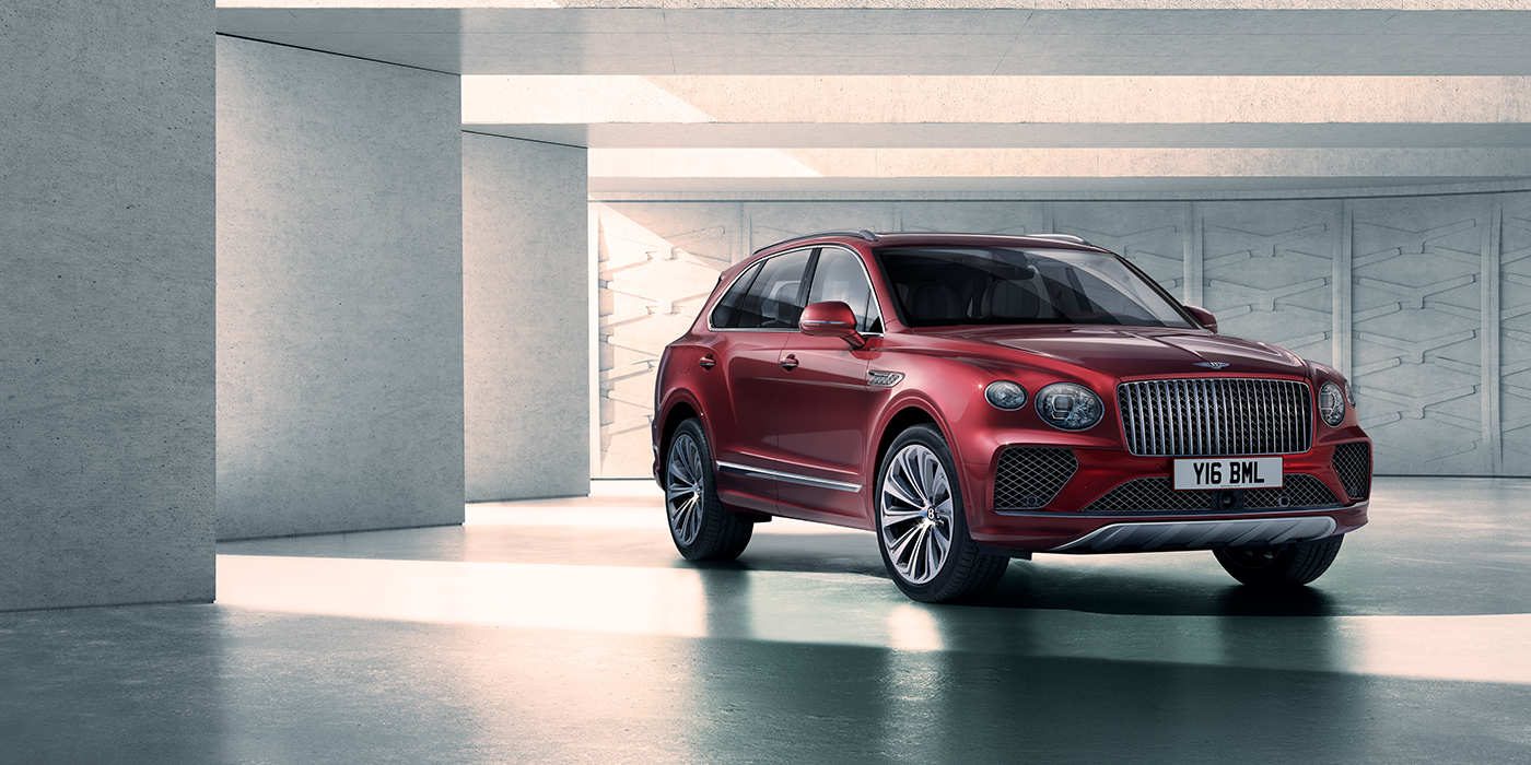Bentley Leeds Bentley Bentayga Atelier Edition SUV in Rubino Red paint front three quarter against textured concrete wall