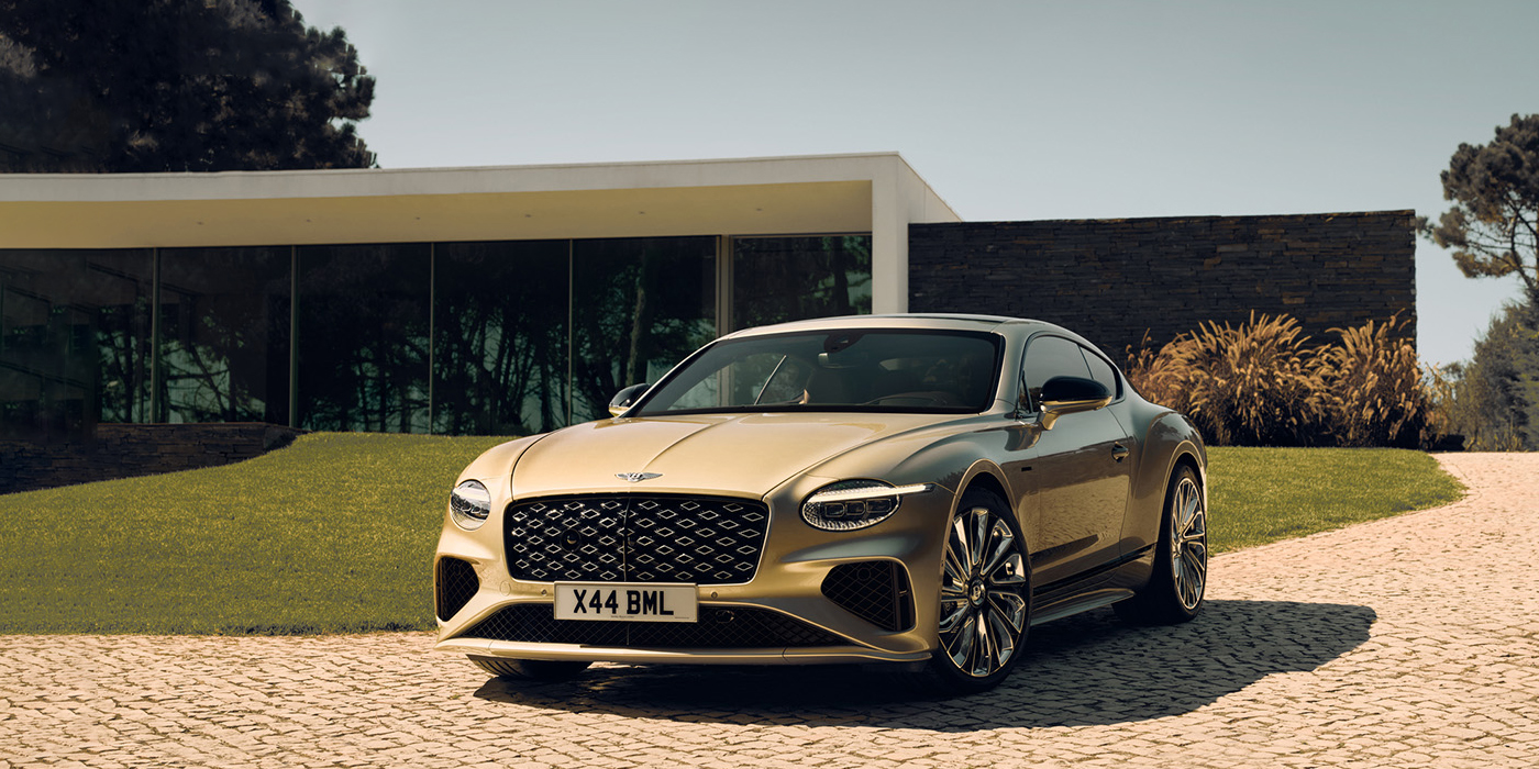 Bentley Leeds Bentley Continental GT Mulliner coupe front three quarters in Patina paint parked outside a glass fronted building with a grass lawn behind it