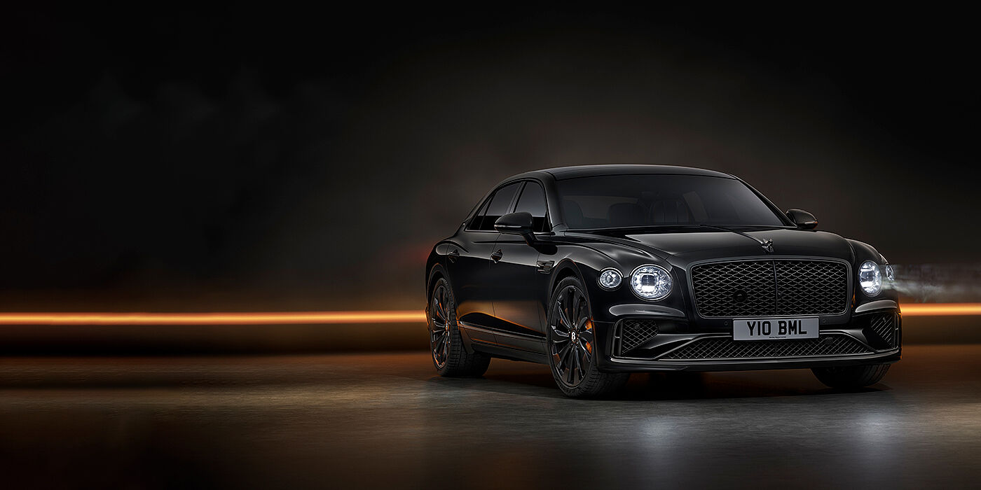 Bentley Leeds Bentley Flying Spur Black Edition sedan in Black Crystal paint against a dark grey and copper coloured background