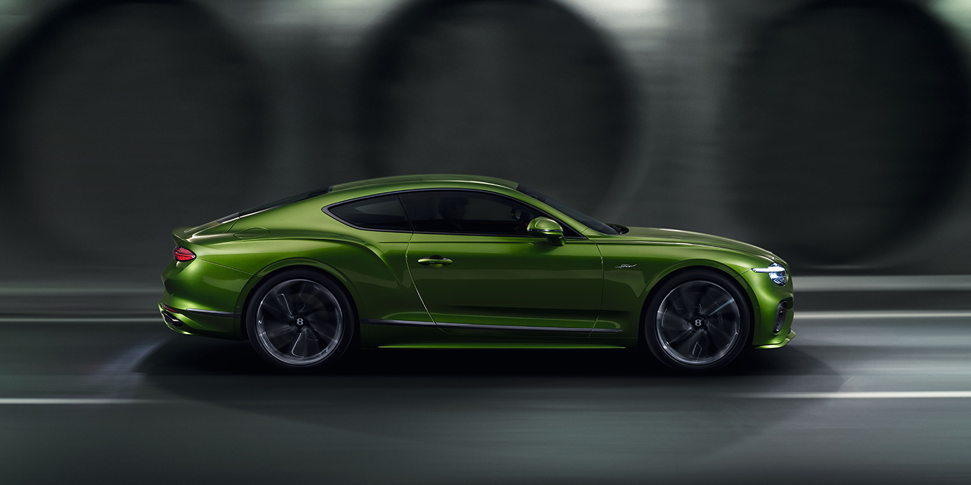 Bentley Leeds Bentley Continental GT coupe in Tourmaline Green paint driving in profile on a dark road