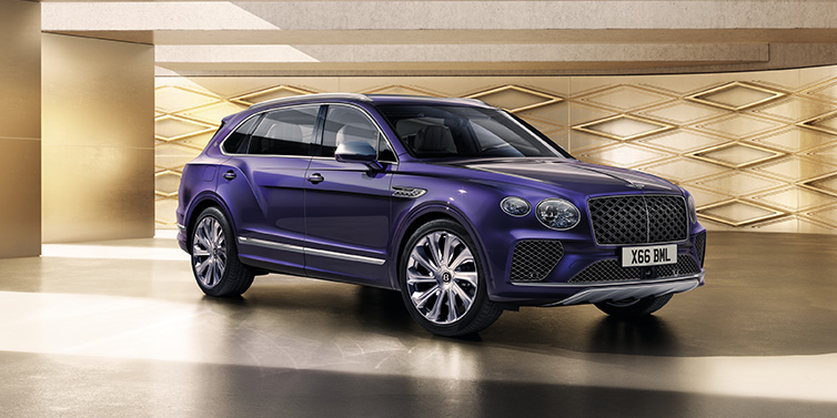 Bentley Leeds Bentley Bentayga Extended Wheelbase Mulliner SUV front three quarter in Tanzanite Purple paint with a gold patterned background